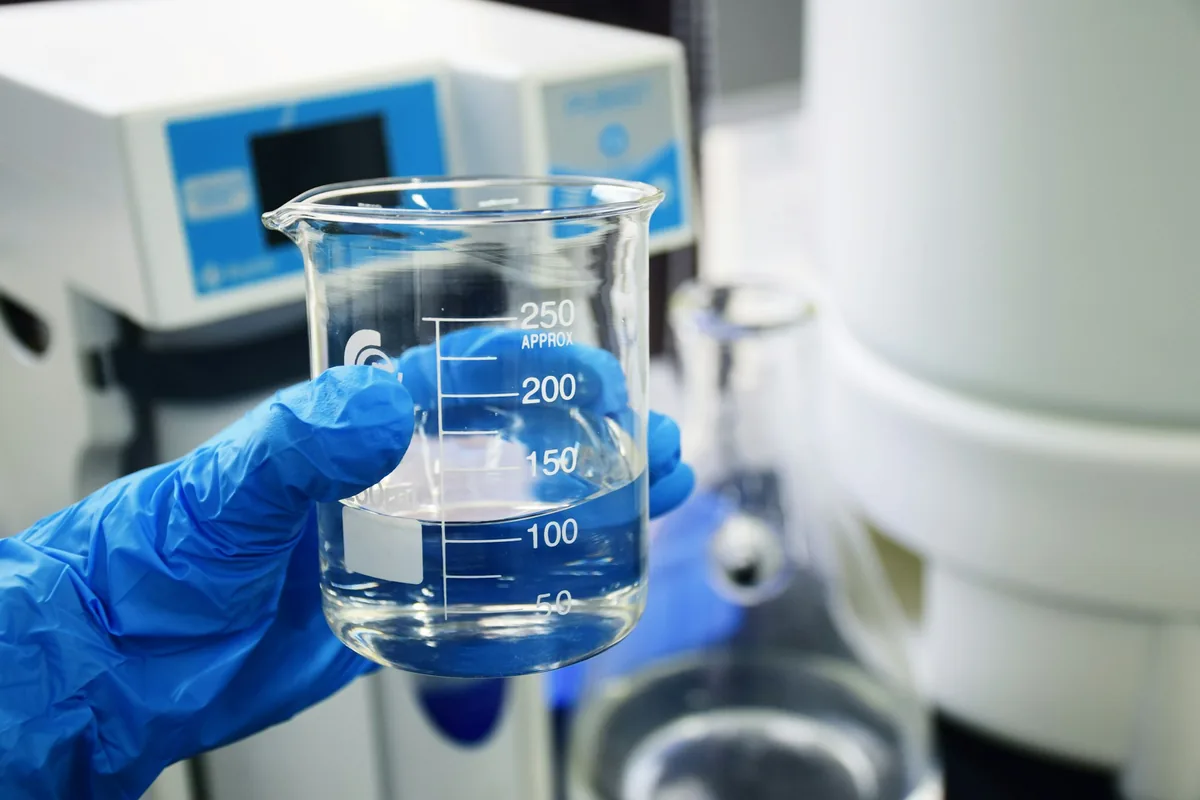 理化学用ガラス器具の取扱い（業界イメージ。実際の同社の現場・製品ではありません）